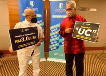 YUSERRIE Zainuddin (kanan) menunjukkan nombor plat khas UC yang dibuka untuk jualan awam bermula esok, 25 Februari sambil diperhatikan Abdul Aziz Abdul Rahman di Kuantan, Pahang.