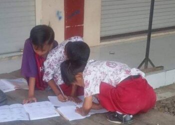 GAMBAR dua murid sekolah rendah belajar di kaki lima pasar di Luwu, Sulawesi Selatan menjadi tular dalam media sosial. - AGENSI