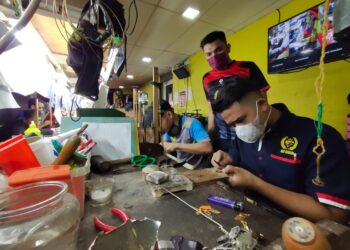 MURTADHATUMIZI Mustapha (berdiri) memerhatikan tukang emas menyiapkan tempahan pelanggan di Kota Bharu, Kelantan. - UTUSAN/YATIMIN ABDULLAH