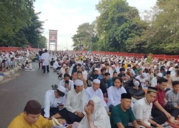 RIBUAN penduduk di Palembang membanjiri kawasan lapang di Jambatan Ampera untuk menunaikan solat sunat Aidilfitri.-AGENSI