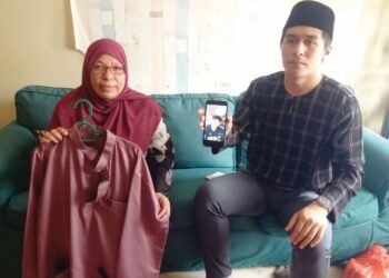 HIZANAWATI Abu Bakar (kiri) dan Ketua Pemuda UMNO Kuala Selangor, Mohammad Aliff Asyraf menunjukkan baju Melayu terakhir serta gambar Muhammad Damin Mikhail Kamsol di Bandar Puncak Alam Fasa 3, Kuala Selangor, Selangor. - UTUSAN/ISKANDAR SHAH MOHAMED