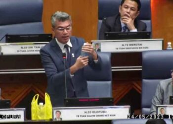 CALVIN Chong menunjukkan sampel air masin yang dibawa dari Sandakan pada persidangan DUN hari ini