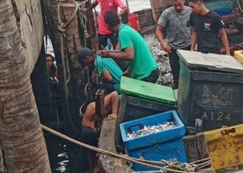 MANGSA lemas jatuh dari bot dibawa naik selepas ditemukan di jeti sebuah kilang pemprosesan ikan di Kampung Acheh, Sitiawan semalam. - UTUSAN/IHSAN JBPM
