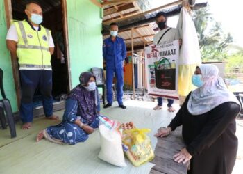 NOOR SURYANTI( kanan) menyampaikan sumbangan kepada Nik Zah di Pulau Perhentian, Besut, Terengganu. - UTUSAN/ROHANA MOHD. NAWI