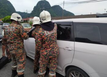 ANGGOTA bomba membuka pintu kereta Proton Exora bagi menyelamatkan tiga beradik terperangkap di dalam kereta di Taman Perpaduan di Ipoh hari ini. - UTUSAN/IHSAN JBPM