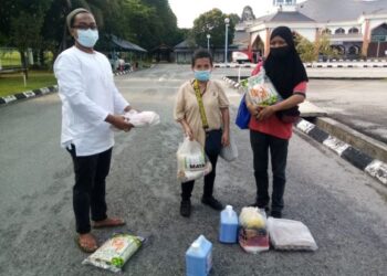 LOIDA (kanan) bersama seorang rakannya menerima sumbangan makanan daripada wakil Saiful Nizam (kiri) di Masjid An-Nur, Shah Alam, Selangor. - UTUSAN / MOHAMAD NAUFAL MOHAMAD IDRIS