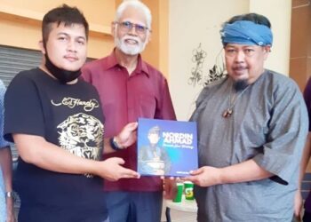 HIDIR Ali Razali (kiri) menyerahkan buku tulisannya kepada Allahyarham Mamat Khalid dalam satu pertemuan baru-baru ini.