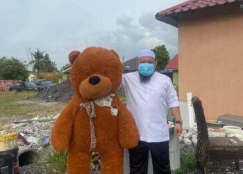 Mohamad NorHezri bersama patung beruang yang didakwa menjadi tempat tinggal jin.