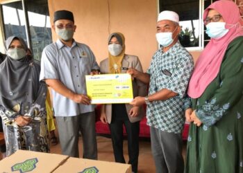 MOHD. Rusli Abdullah  (dua kiri) menyerahkan cek khairat kematian kepada keluarga Allahyarham Nurul Syahirah M.Roni sambil diperhatikan Nora Yaacob (tengah) di Kampung Delima Wakaf Bharu, Tumpat, hari ini .- UTUSAN/ROSLIZA MOHAMED