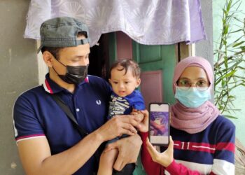 SITI Zubaidah Ibrahim (kanan) dan Emirol Nordin bersama anak mereka, Mohammad Habib Andra yang mengalami melecur dan masih menjalani rawatan susulan ketika ditemui di Kampung Kurnia Diraja, Gemas, Tampin, semalam. - UTUSAN/NOR AINNA HAMZAH