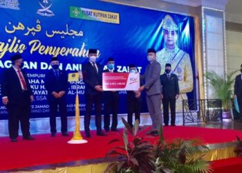 TENGKU HASSANAL IBRAHIM ALAM SHAH Al-Sultan Abdullah (tiga, kiri) secara simbolik menerima replika penyerahan zakat perniagaan daripada Ketua Pegawai Eksekutif Kumpulan FGV, Mohd. Nazrul Izam Mansor (dua, kanan) sebanyak RM4.5 juta di Majlis Penyerahan Zakat Perniagaan dan Anugerah Zakat di Kuantan, Pahang. - FOTO/ DIANA SURYA ABD WAHAB