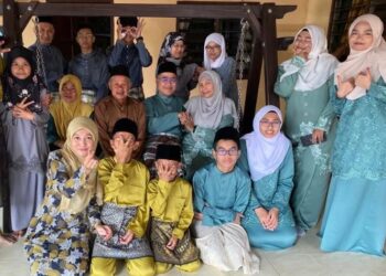 SEBAHAGIAN ahli keluarga Abdullah Mamat yang tinggal berjauhan merakam gambar kenangan semasa berkumpul sempena sambutan Hari Raya Aidilfitri di Kampung Simpang Rawai, Marang, Terengganu.