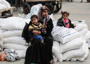 SEORANG penduduk Palestin duduk bersama anaknya selepas menerima bantuan makanan kem pelarian Khan Yunis di selatan Semenanjung Gaza. - AFP