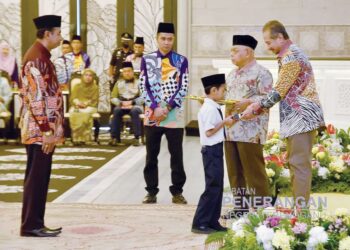 SULTAN Mizan Zainal Abidin mengurniakan bantuan kepada salah seorang pelajar sempena Hari Raya Aidilfitri di Istana Syarqiyyah, Chendering Kuala Terengganu. - UTUSAN/KAMALIZA KAMARUDDIN
