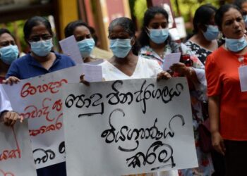 PETUGAS kesihatan memegang sepanduk dan melaungkan slogan menentang Presiden Sri Lanka, Ranil Wickremesinghe semasa protes di Colombo. - AFP 