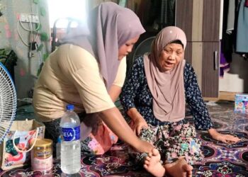 NUR Alia Natasha Nawi (kiri) menjaga ibunya yang sakit saraf di rumahnya di RKT Kesedar Paloh 2, Gua Musang, Kelantan. – UTUSAN/AIMUNI TUAN LAH