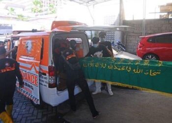 KERANDA yang membawa jenazah Sarijan dimasukkan ke dalam ambulans untuk dikebumikan. - AGENSI