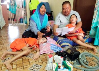 SALINA Abu Bakar bersama suaminya dan anak kembar mereka yang menghidap celebral palsy ketika ditemui dirumahnya di Taman Seri Pagi, Senawang, Seremban. – UTUSAN/NOR SHAFAWATI YUP