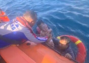 TANGKAP layar video menunjukkan pasukan keselamatan menyelamatkan seorang wanita dan bayinya selepas terjun ke dalam laut susulan insiden bot terbakar di Kupang. - AGENSI