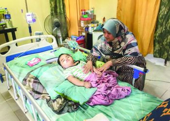 HAMIZAH Hamdan sentiasa memantau keadaan anaknya, Muhammad Yusuf Mohd. Azmi di Kampung Dendang,Ketereh, Kota Bharu, Kelantan. – UTUSAN/ROSMIZAN RESDI