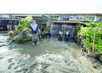 PENDUDUK Pekan Kuala Kedah mencuci rumah yang dipenuhi lumpur setelah berlaku banjir kilat akibat fenomena air pasang besar di Kuala Kedah. – UTUSAN/JAMLIAH ABDULLAH