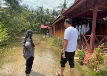 DR. MUHAMAD Akmal Saleh meninjau kawasan rumah yang dipanda air pasang besar di Merlimau.