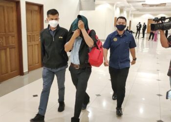 MOHD. NORIZAN Yahaya (tengah) tidak mengaku bersalah selepas didakwa atas 32 pertuduhan menerima suapan dari seorang nelayan di Mahkamah Sesyen Kuantan di Kuantan, Pahang. - UTUSAN/ DIANA SURYA ABD. WAHAB