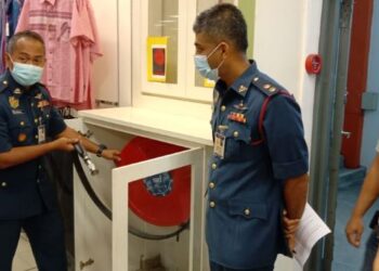 SHAZLEAN Mohd. Hanafiah (kiri) memeriksa hos penyembur air di Pasar Raya Billion Seri Manjung hari ini. - UTUSAN/
SHAMSUL KAMAL AMARUDIN