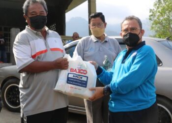 ABDUL FATTAH Abdullah (kanan) menyampaikan bantuan barangan keperluan harian kepada ahli koperasi yang menjadi mangsa banjir di Kampung Chegar Medang di Bentong, Pahang. - UTUSAN/SALEHUDIN MAT RASAD
