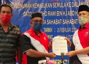MOHD. Rawi Abd Hamid (kanan) menyerahkan borang keahlian UMNO kepada Setiausaha UMNO Bahagian Langkawi, Nordin Ali di Langkawi petang ini. - UTUSAN/NUR AMALINA AZMAN