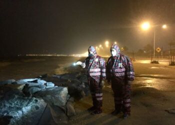 MD. Hilman Abd. Rashid (kiri)  meninjau keadaan di Pantai Seberang Takir di sini, malam tadi. - TENGKU DANISH BAHRI TENGKU YUSOFF