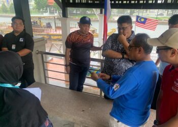 AB. RAUF Yusoh diberi penerangan oleh kakitangan PPSPM berhubung kematian ribuan spesies ikan di Taman Rempah, Melaka. - UTUSAN/AMRAN MULUP
