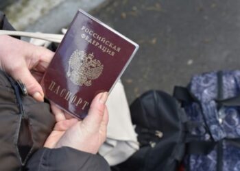 SEORANG wanita memegang pasport Russia semasa menunggu usaha menyelamat di bandar Donetsk.-AFP