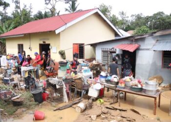 PENDUDUK membersihkan rumah mereka hari ini selepas dilanda banjir lumpur petang semalam di Felda Trolak Selatan dekat Tanjung Malim. - UTUSAN/MUHAMAD NAZREEN SYAH MUSTHAFA