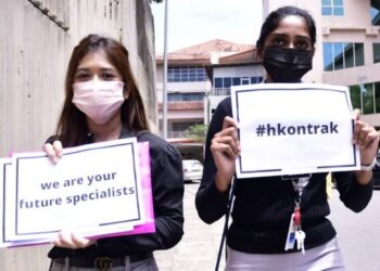 Dua pegawai perubatan kontrak  mengadakan protes aman Hartal Doktor Kontrak di Hospital Queen Elizabeth Kota Kinabalu, Julai lalu.