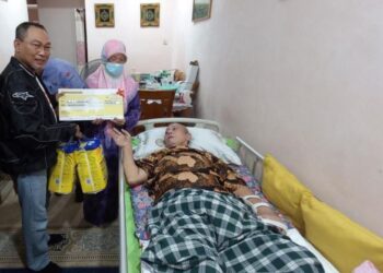 NORHAYATI Mohd. Nor menerima ELS berjumlah RM500 yang diserahkan Awang Hashim di Taman Kelemak Jaya, Alor Gajah, Melaka. - UTUSAN/AMRAN MULUP