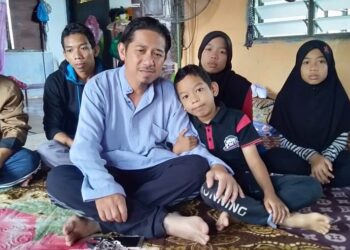 AHMAD Hazli Hassan (depan) ditemani anak-anaknya termasuk Siti Rohmah Hayati (belakang, dua kanan) ketika ditemui di rumah mereka di Kampung Perlis, Simpor, Tikam Batu. - UTUSAN/OTHMAN YAHAYA