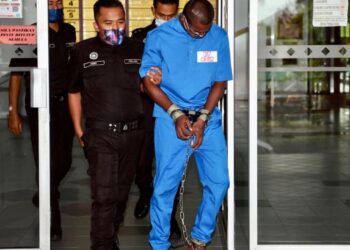 TERTUDUH (dua kanan) dibawa oleh anggota polis untuk perbicaraan berkait kes dadah di Mahkamah Tinggi Kota Bharu, Kelantan hari ini.UTUSAN/ROSALWANI CHE SOH