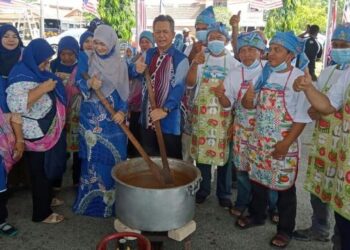 DR. Ahmad Razif (tengah) menyertai gotong-royong mengacau bubur asyura di pekarangan pejabat DUN Seberang Takir, Kuala Nerus, hari ini.