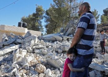 SEORANG penduduk Palestin bersama anak perempuannya berdiri di tepi rumah mereka yang dirobohkan pihak berkuasa Israel di Kawasan C di kampung Beit Ummar di utara Hebron pada Oktober 2019. – AFP