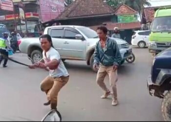 TANGKAP layar video menunjukkan seorang lelaki dengan parang dan kerambit cuba mengejar polis trafik yang menyaman anaknya di Sumatera Selatan. - AGENSI