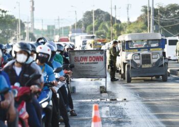 PENUNGGANG motosikal dari wilayah Rizal semasa melalui sekatan di kawasan sempadan bandar Quezon, Filipina. -AFP