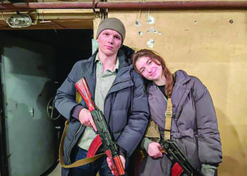 SVIATOSLAV Fursin dan isterinya, Yaryna Arieva memegang senapang AK-47 selepas mendaftar sebagai tentera Ukraine. - AGENSI