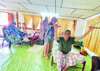 ZAIDAWATI Zainol membantu Azlan Ismail melakukan fisioterapi bagi memulihkan anggota badan yang lumpuh di rumah mereka di Kampung Selarong Panjang Kangkong, Alor Setar. – UTUSAN/JAMLIAH ABDULLAH