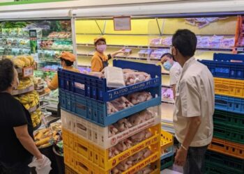 PEKERJA meletakkan stok ayam yang dijual di premis FairPrice di Bedok Mall.-CNA