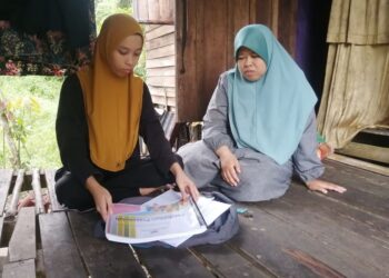 AINUN MARDIAH Mat Lazim (kiri) mengemas buku-buku pengajiannya sambil diperhatikan  ibunya, Roslindawati Abd. Rahman di rumah sewa mereka di Kampung Bukit Ara, Ajil, Hulu Terengganu, hari ini. - UTUSAN/NOOR HAYATI MAMAT