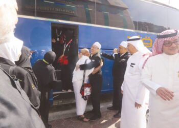 SYED Saleh Syed Abdul Rahman memeluk salah seorang jemaah sambil diperhatikan oleh Adnan Hussain (dua dari kanan) di Abraj Janadriyah, Mekah semalam.