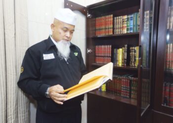 Tengku Aziz menunjukkan kitab rujukan yang digunakan untuk mengetahui mengenai rukun dan wajib haji ketika ditemui di pejabatnya di Abraj, Janadriah, Mekah semalam.