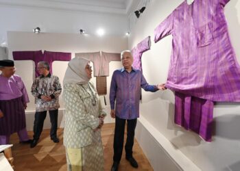ISMAIL SABRI Yaakob meneliti kain tenun Pahang sambil diperhatikan Tunku Azizah Aminah Maimunah Iskandariah dalam  sesi lawatan ke Pameran Tenun Pahang Diraja yang diadakan buat julung kalinya di Suruhanjaya Tinggi Malaysia di Belgrave Square, sempena Minggu Kraf London (London Craft Week) dari 9 hingga 15 Mei 2022.