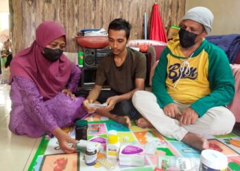 FARIS Danial Mohd. Amir Raja (tengah) bersama ibu bapanya ketika ditemui di rumah sewa mereka di Taman Warisan Puteri, Seremban, Negeri Sembilan.- MINGGUAN/NOR SHAFAWATI YUP